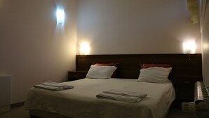 Ein Hotelzimmer mit einem großen Bett, zwei Nachttischen und einer Kopfteil.
