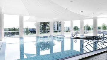 Una piscina techada, sillones reclinables de piscina