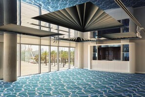 A spacious interior with large windows, a patterned floor, and a modern ceiling design. - W Barcelona (Barcelona)
