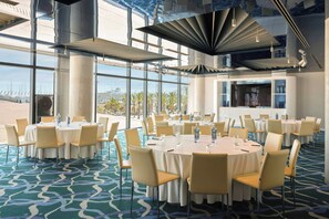A conference room with round tables, chairs, and a large screen. - W Barcelona (Barcelona)
