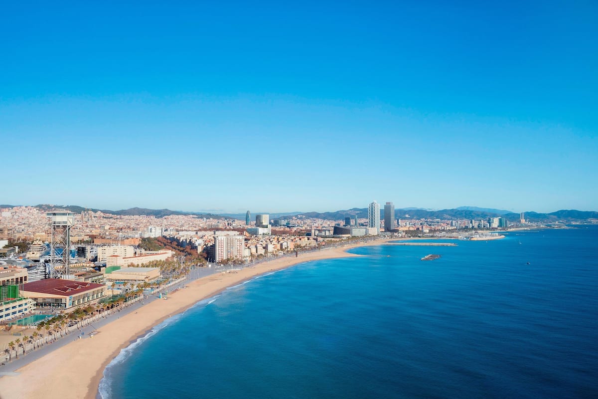 Un paysage urbain côtier avec une plage, des bâtiments et un ciel bleu dégagé.