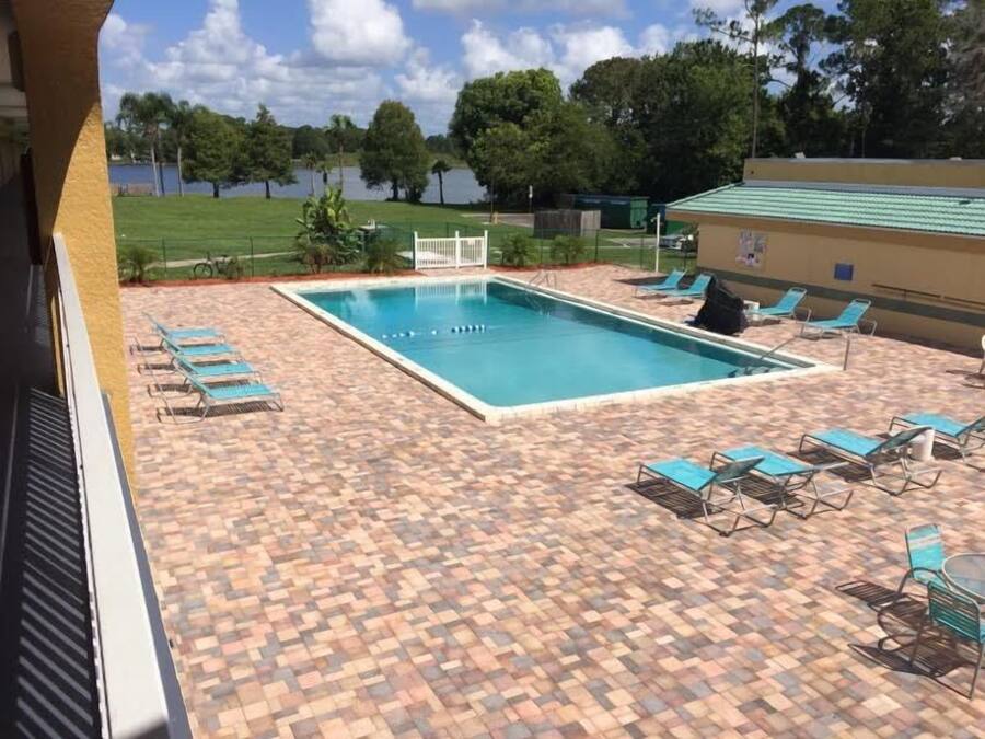 Een buitenzwembad, ligstoelen bij het zwembad