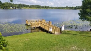 A wooden dock extending into a calm lake surrounded by lush greenery. - Budget Inn Sanford (Sanford)