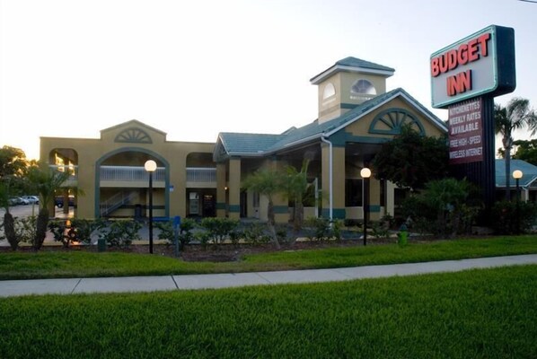 A Budget Inn hotel with a two-story structure, a prominent sign, and a landscaped front yard.