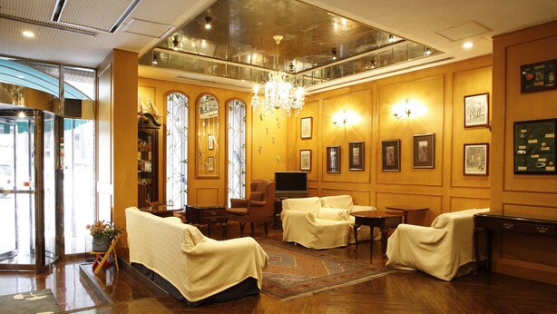 A lobby with wooden flooring, a chandelier, and a reception desk. - Hotel Sunlife (Osaka)