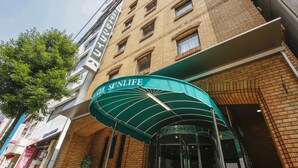 A hotel entrance with a green awning labeled "Sunlife." - Hotel Sunlife (Osaka)