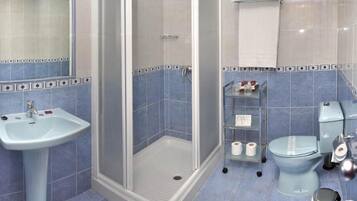 Une salle de bain équipée d’une douche, d’un lavabo, de toilettes et d’un bidet.