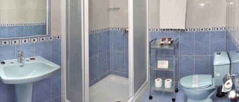Un baño con ducha, lavamanos, inodoro y bidé.