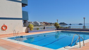 A rooftop pool with clear blue water, a lifebuoy, and a view of the sea and buildings in the background. - Arrayanes Playa Hotel (Almunecar)