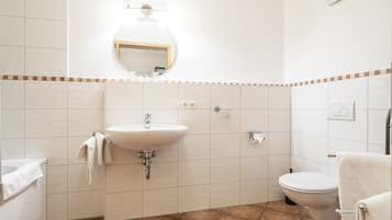 Ein Badezimmer mit Waschbecken, Toilette und Spiegel.