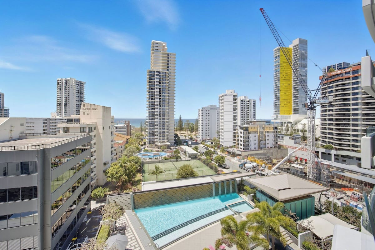 A high-rise building with a swimming pool and a tennis court.