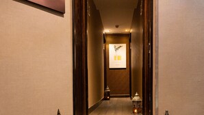 A hotel hallway with a Buddha statue, a poster, and a staircase with lights. - Bryn Meadows Golf, Hotel & Spa (Blackwood)