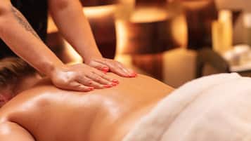 A massage therapy session in a spa setting with a person receiving a back massage.