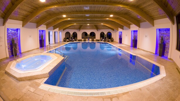 An indoor swimming pool with a hot tub, wooden beams, and arched doorways. - Bryn Meadows Golf, Hotel & Spa (Blackwood)