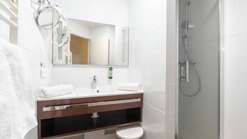 Une salle de bain moderne avec un lavabo blanc, un miroir et des toilettes.