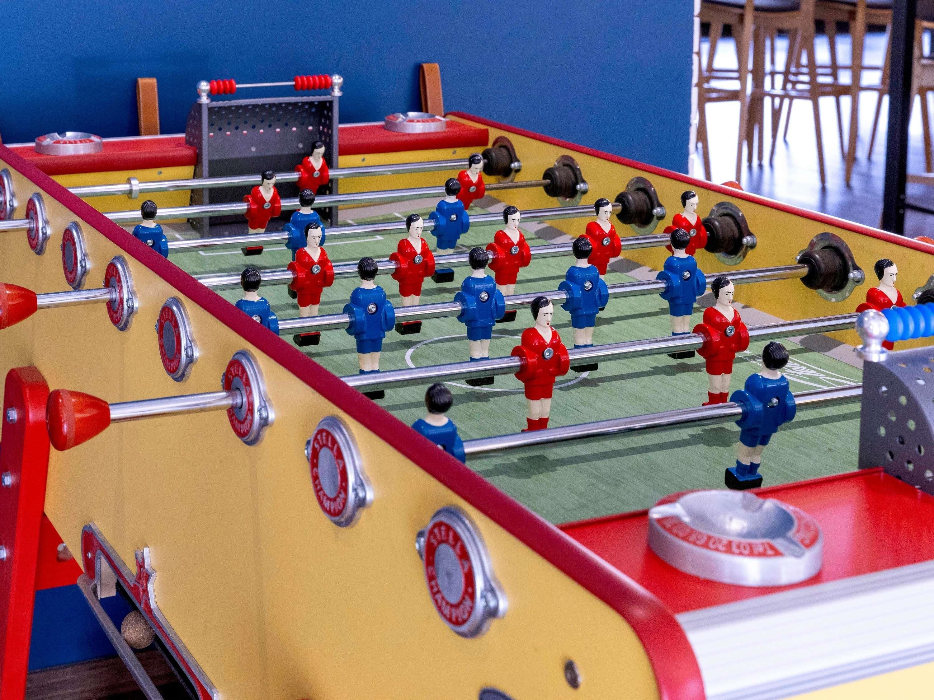 Una mesa de fútbol de mesa con figuras de jugadores en rojo y azul.