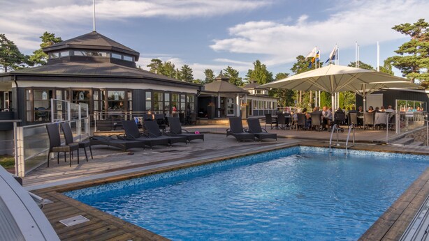 A pool area with lounge chairs, a covered seating area, and a gazebo-like structure. - Käringsund Resort & Conference (Eckero)