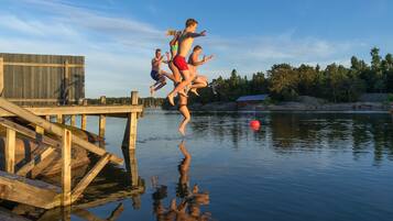 A wooden dock extending into calm water with a clear sky.
