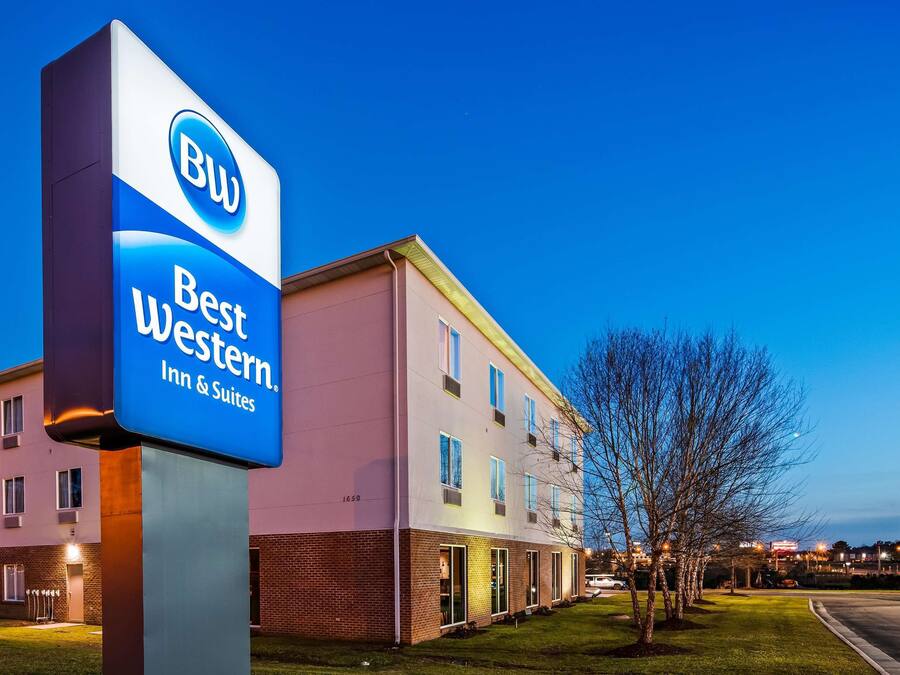 A Best Western Inn & Suites sign with a modern building in the background.