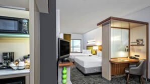 A hotel room with a kitchenette, a TV, a desk, a chair, and a bed. - SpringHill Suites by Marriott San Antonio Airport (San Antonio)