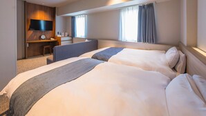 A hotel room with a large bed, a desk, a TV mounted on the wall, and a window with curtains. - New Osaka Hotel (Osaka)