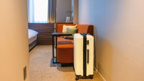 A hotel room with a bed, a small table, a chair, and a suitcase. - New Osaka Hotel (Osaka)