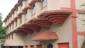 A multi-story building with a unique architectural design, featuring balconies and a red-tiled roof. - Lords Inn Vadodara (Vadodara)