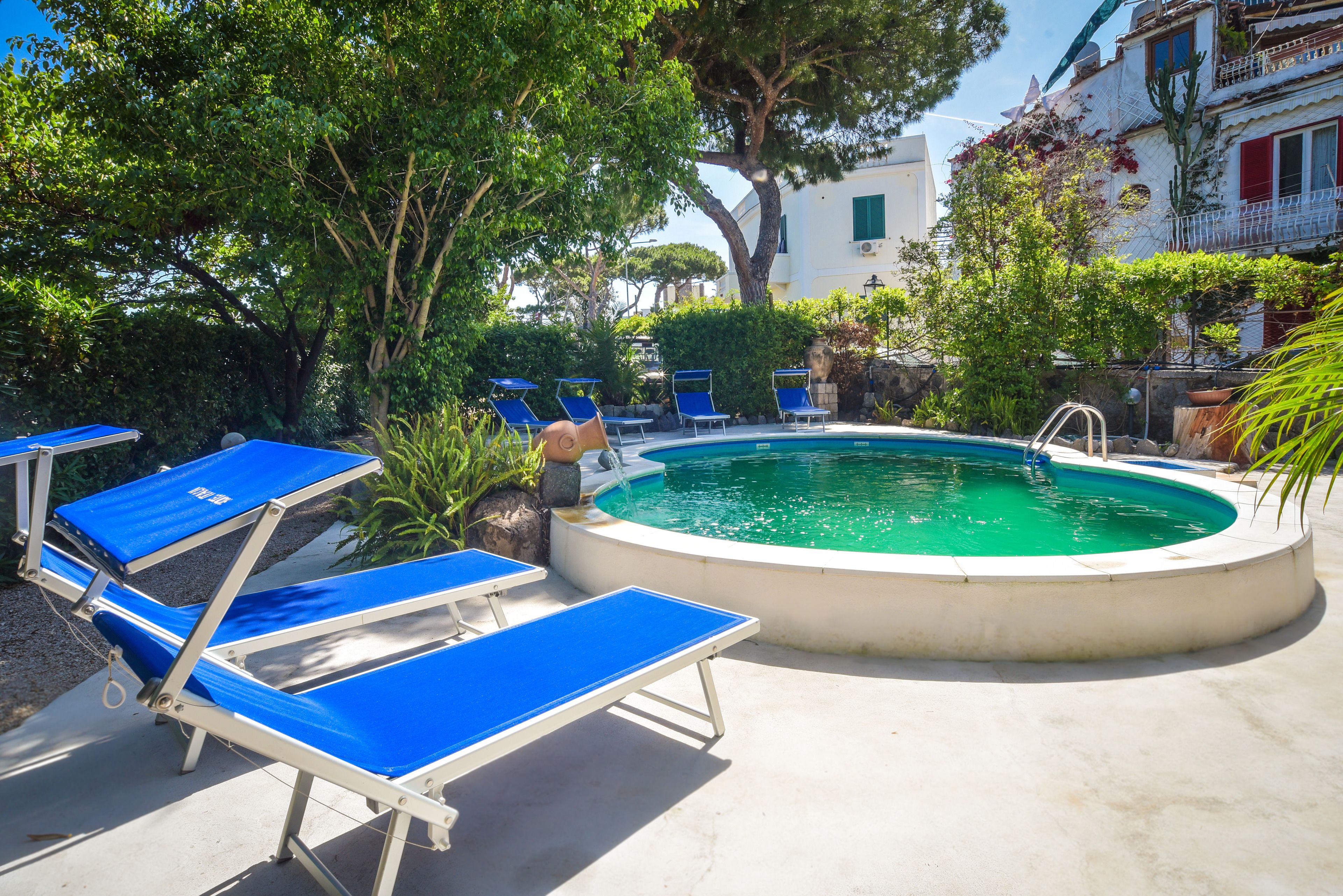 A pool area with blue lounge chairs and a circular pool.