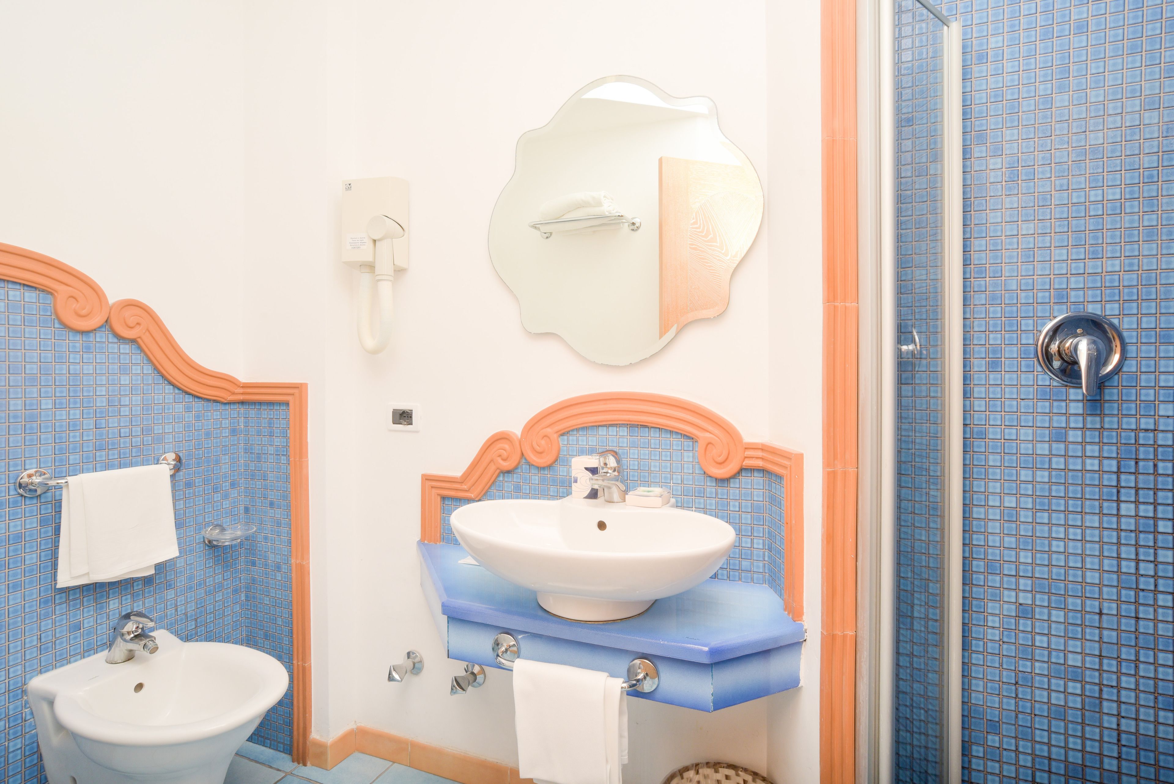 A bathroom with a sink, mirror, and towel rack.