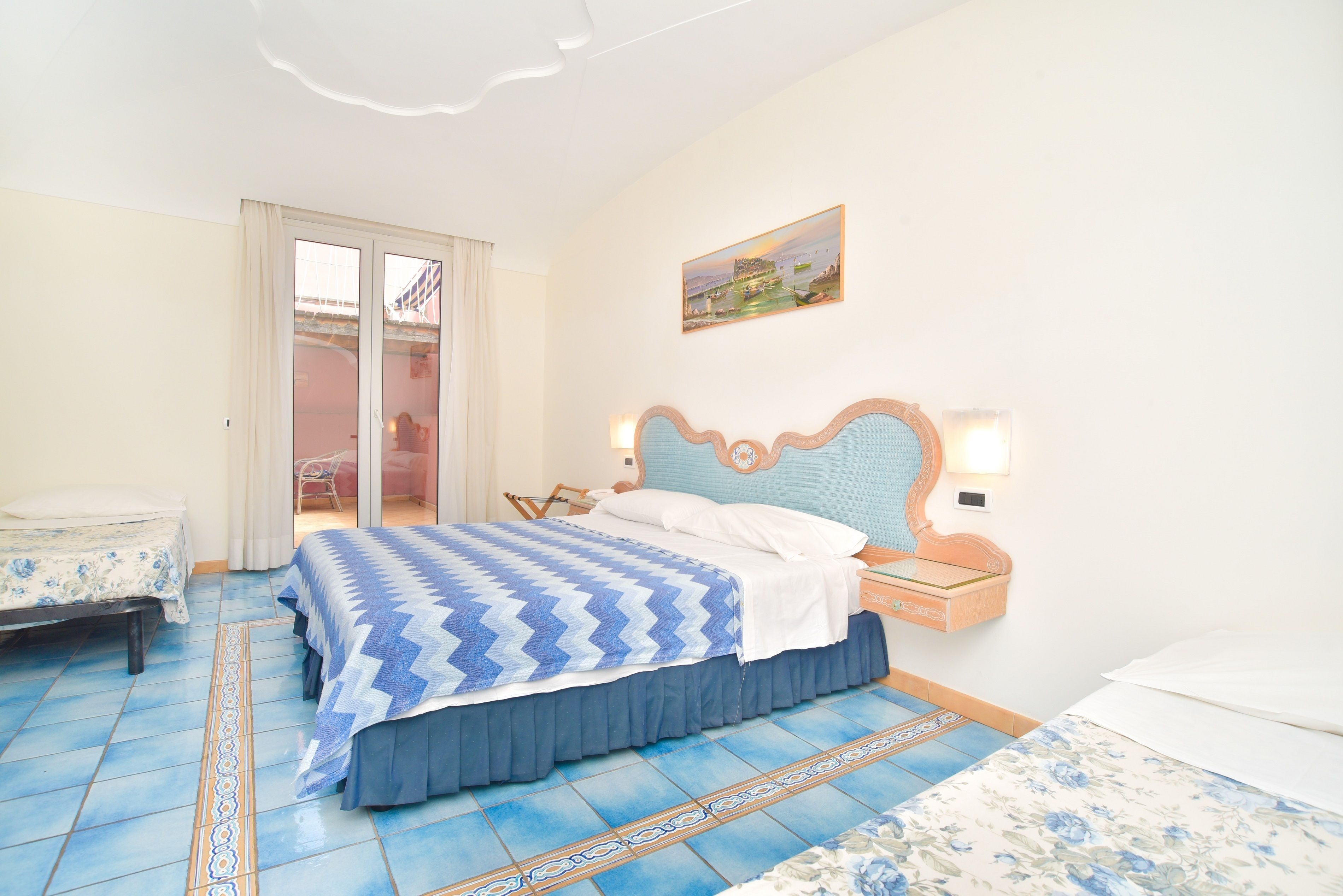 A bedroom with a bed, a nightstand, a chair, and a sliding glass door leading to an outdoor area.