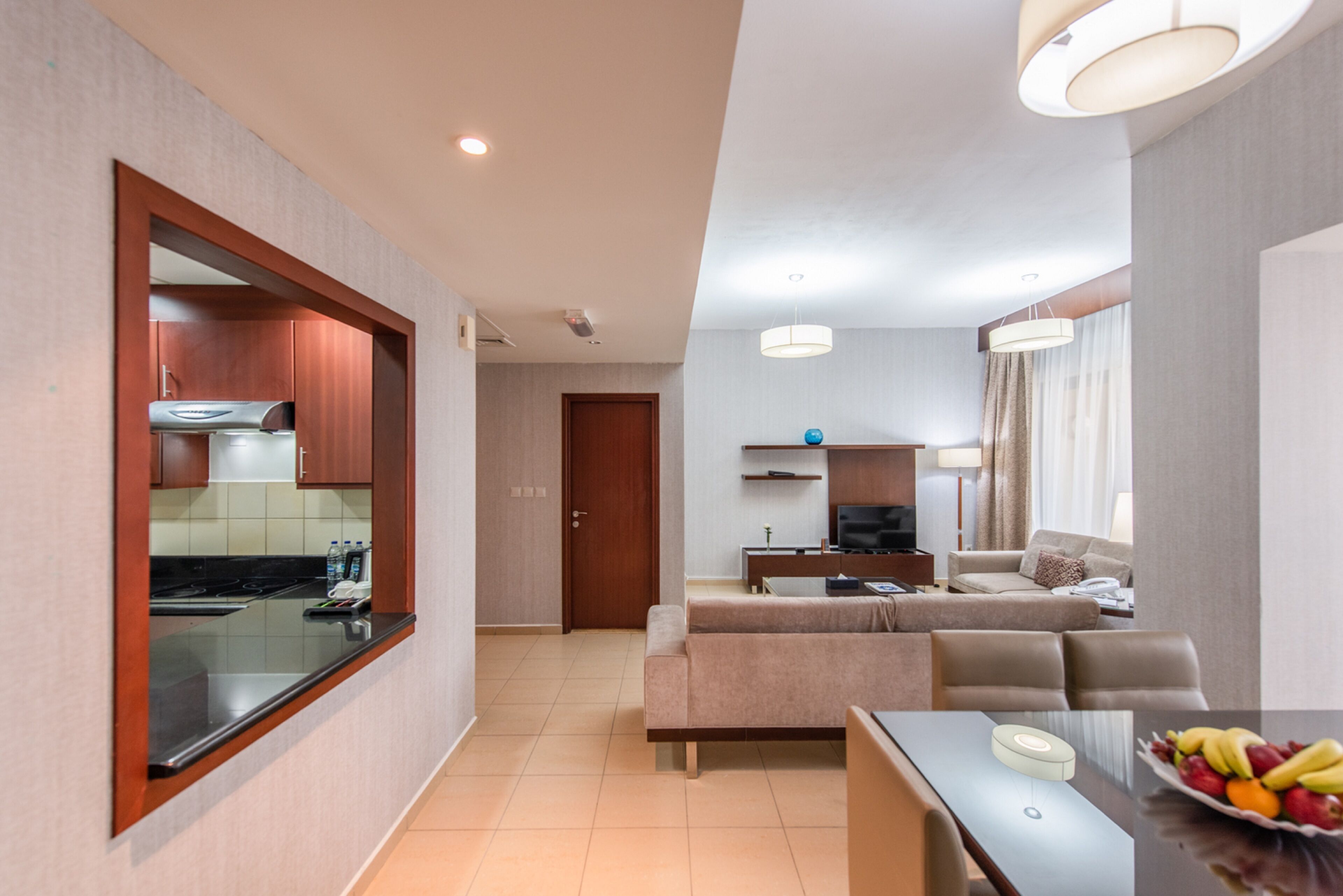 Una sala de estar moderna con un sofá, una mesa de comedor y una zona de cocina con estufa y armarios.
