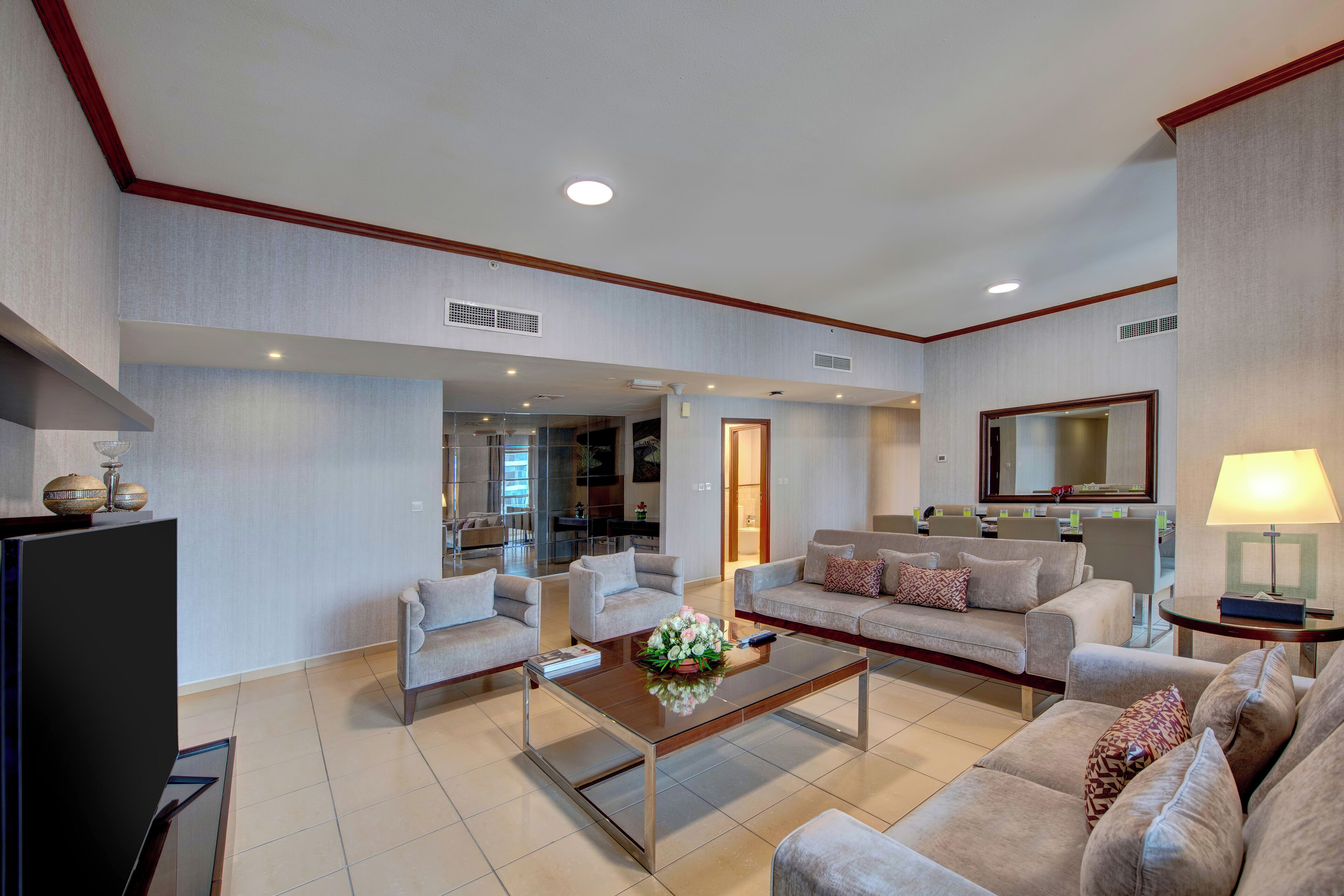 A spacious living area with a sofa set, a coffee table, and a television.