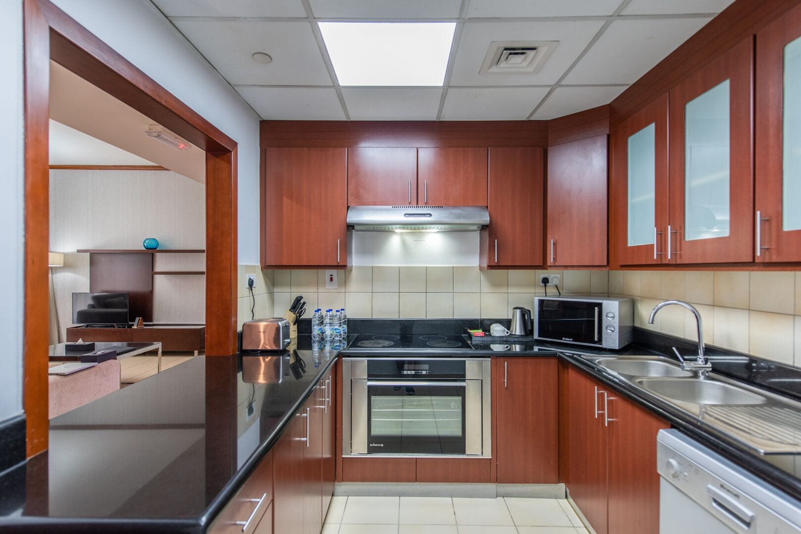 A modern kitchen with wooden cabinets, stainless steel appliances, and a built-in oven.