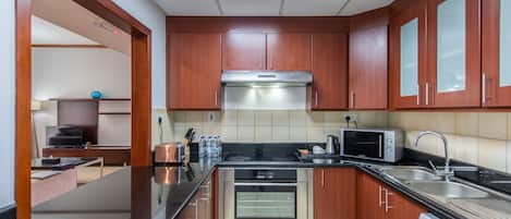 A modern kitchen with wooden cabinets, stainless steel appliances, and a built-in oven.