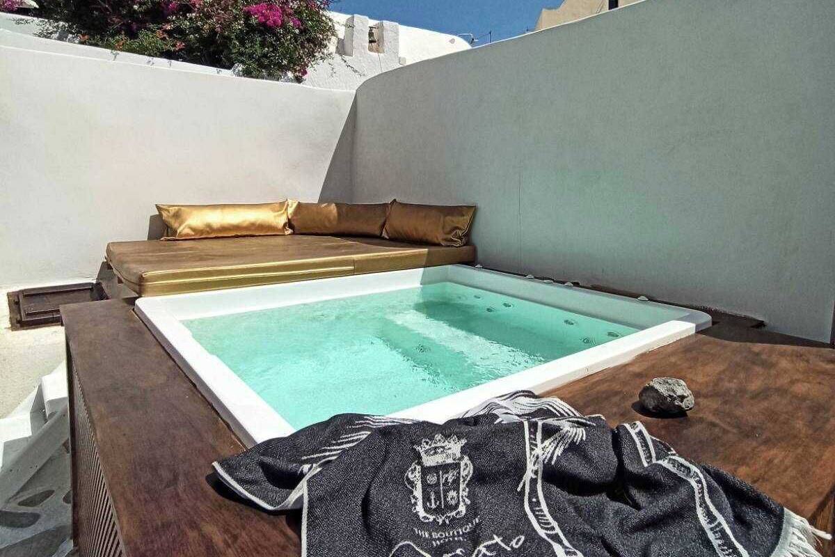 A rooftop pool area with a wooden deck, a lounge chair, and a towel.