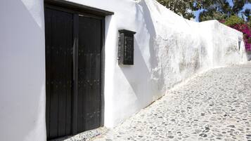 Un edificio blanco con una puerta negra y una ventana pequeña.