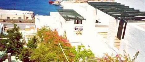 Un edificio costero con paredes blancas y techos verdes, con vista al mar.