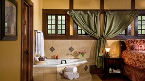 A bathroom with a bathtub, a towel rack, a sink, and a window with curtains. - Hilltop Manor Bed and Breakfast (Hot Springs)