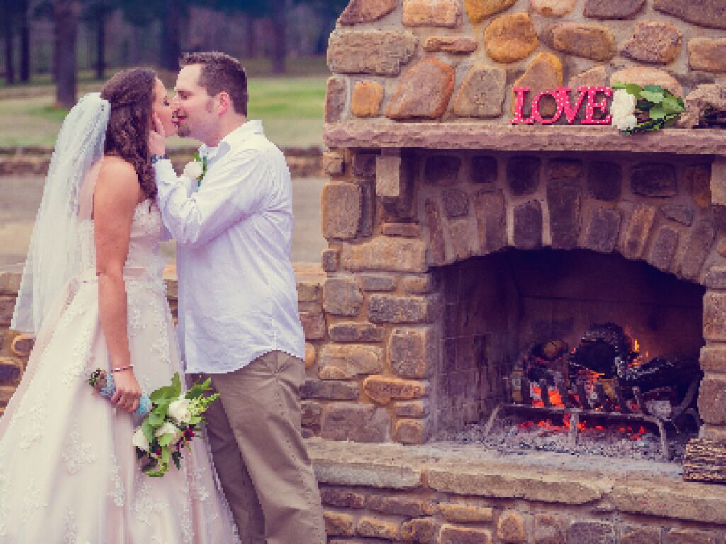 A stone fireplace with a "LOVE" sign above it.