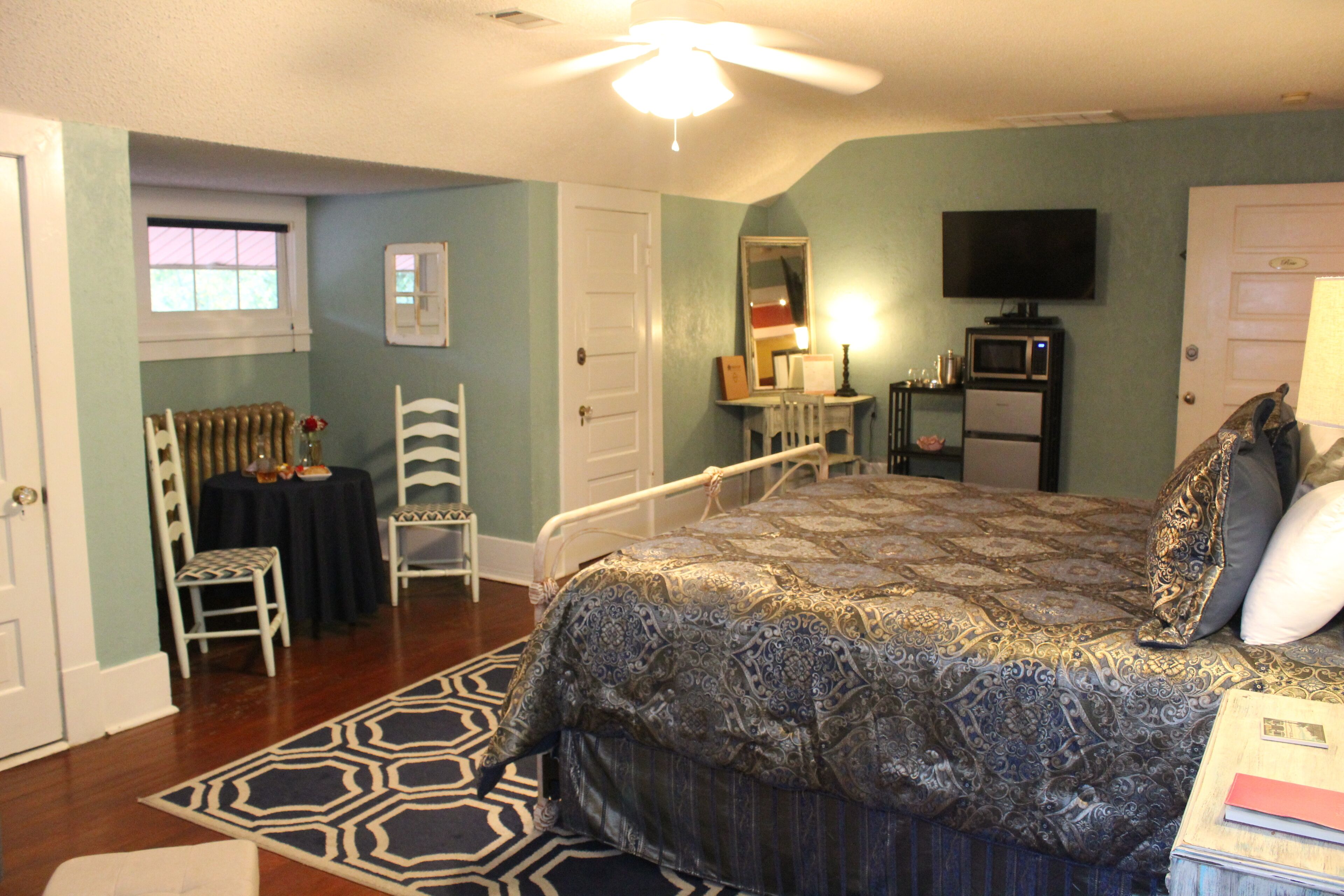 A bedroom with a bed, a television, a mirror, and a radiator.