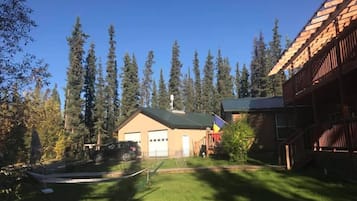 Set amidst a lush forest, this two-story home offers a serene retreat with a garage and driveway.