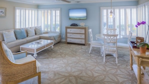 A living room with a sofa, coffee table, and chairs, a television, and a ceiling fan. - Scripps Inn La Jolla Cove (La Jolla)