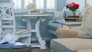 A room with a dining table, a sofa, and a chair. There is a window with blinds, a hanging light fixture, and a lamp on a side table. - Scripps Inn La Jolla Cove (La Jolla)