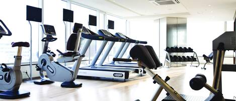Ein Fitnessstudio mit Laufbändern, Ergometer und Krafttrainingsgeräten.