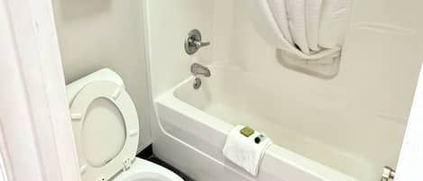 A bathroom with a toilet, bathtub, and shower curtain.
