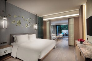 Ein modernes Hotelzimmer mit einem großen Bett, einem Schreibtisch und Blick ins Freie.