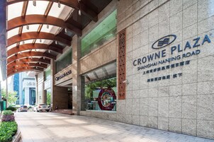 A hotel entrance with a sign for Crowne Plaza Shanghai Nanjing Road.