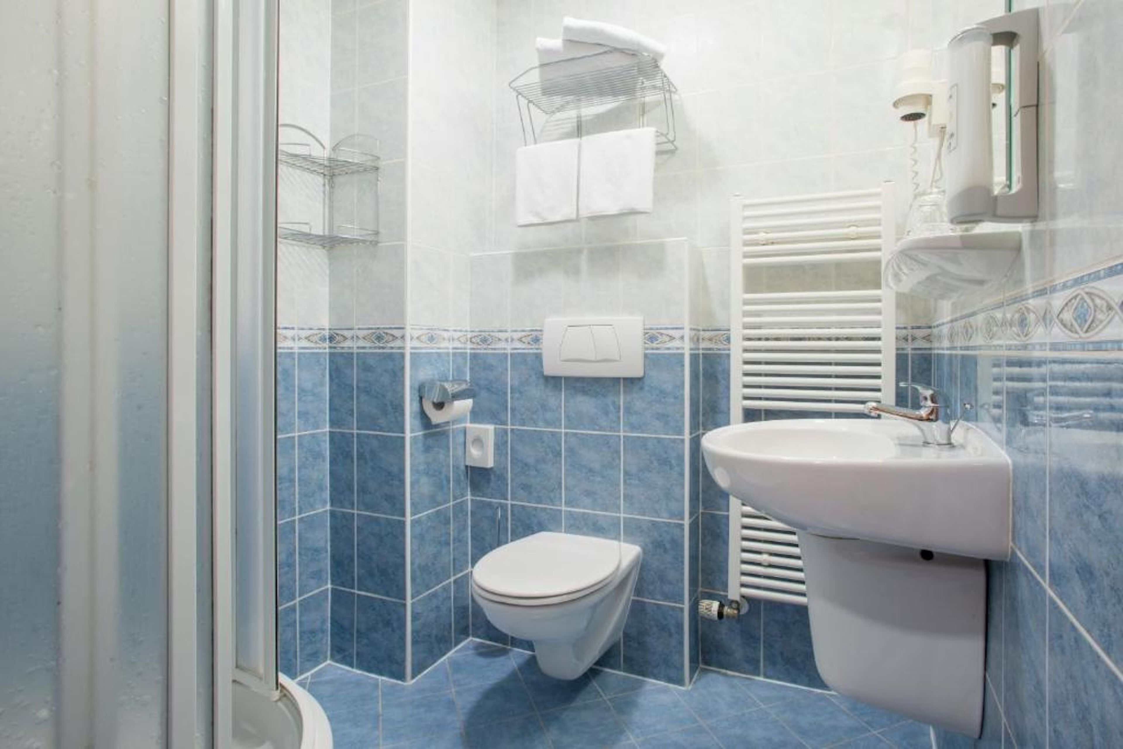Un baño con inodoro, lavamanos y zona de ducha.