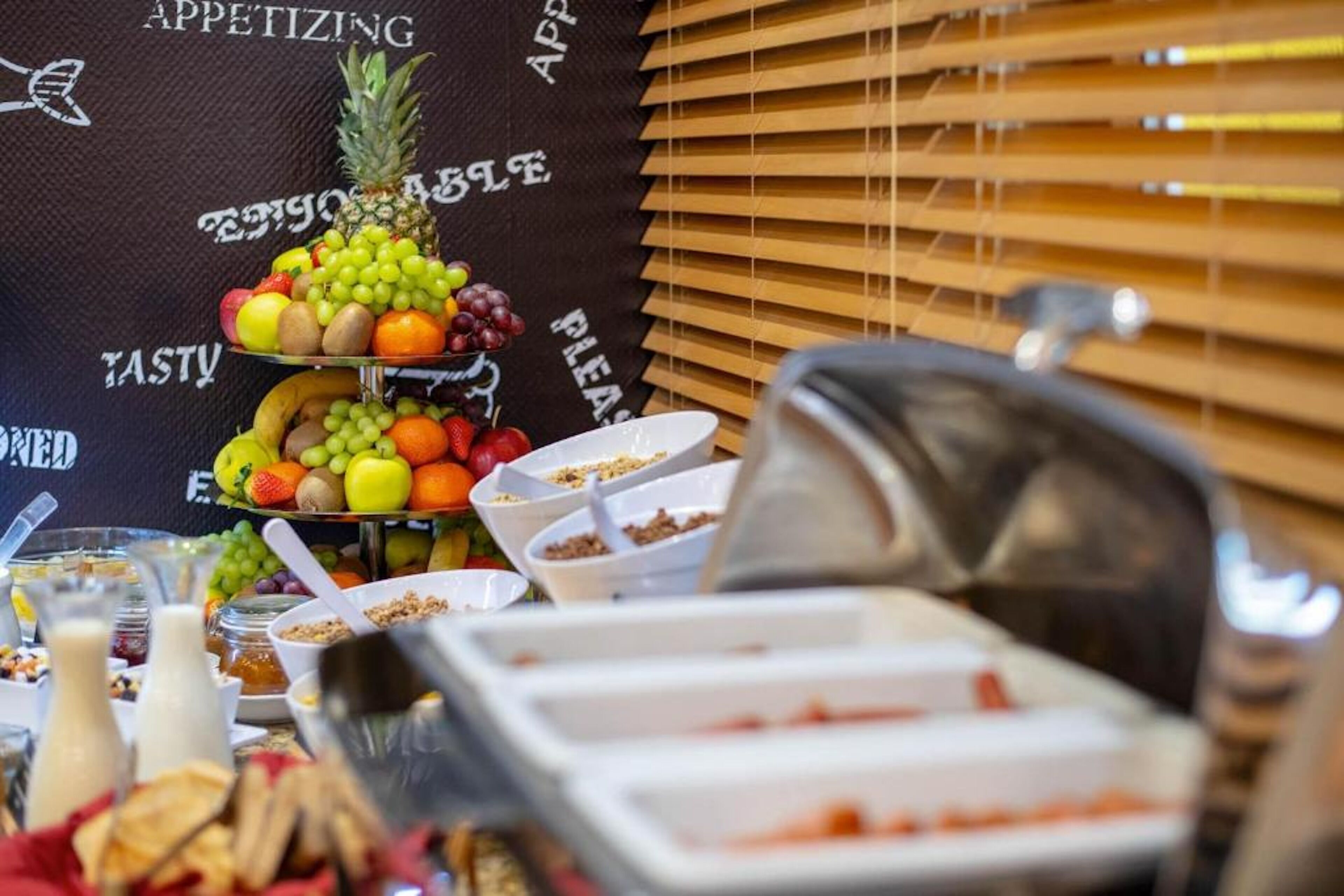A buffet setup with various food items and a fruit display.