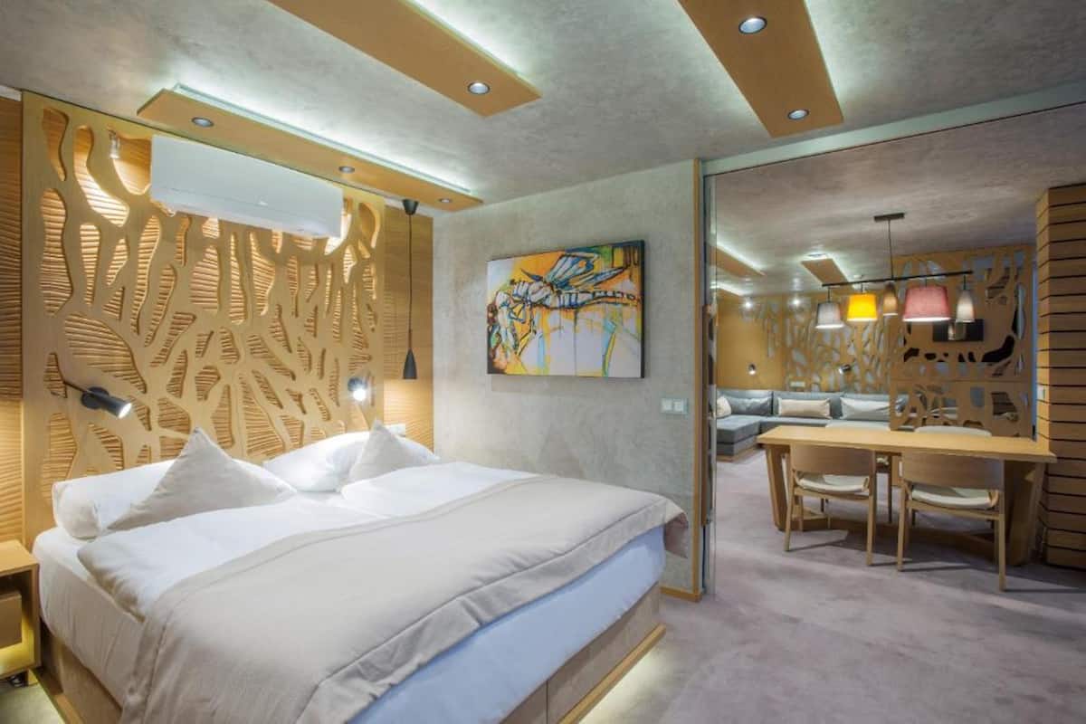 Una habitación de hotel moderna con una cama grande, un escritorio y un espacio para sentarse.